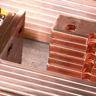 various copper busbars laid out on a table